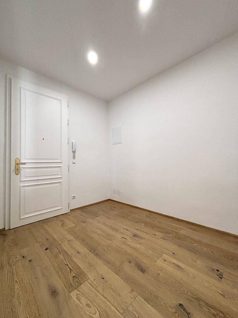 Heller Eingangsbereich mit Holzboden und einer weißen Kassettentür.