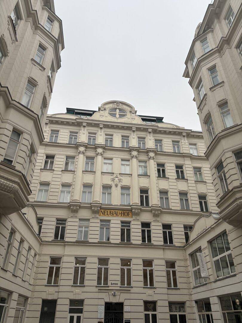 Historisches Gebäude mit aufwendiger Fassade und dem Schriftzug "NEUBAU-HOF".