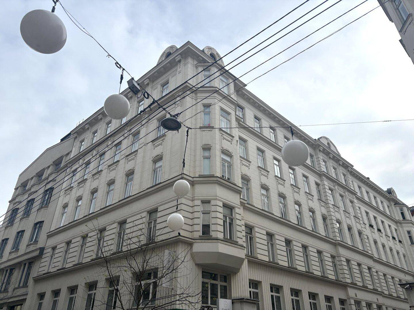 Großes, verziertes Eckgebäude mit vielen Fenstern, typisch für die Architektur einer europäischen Stadt.