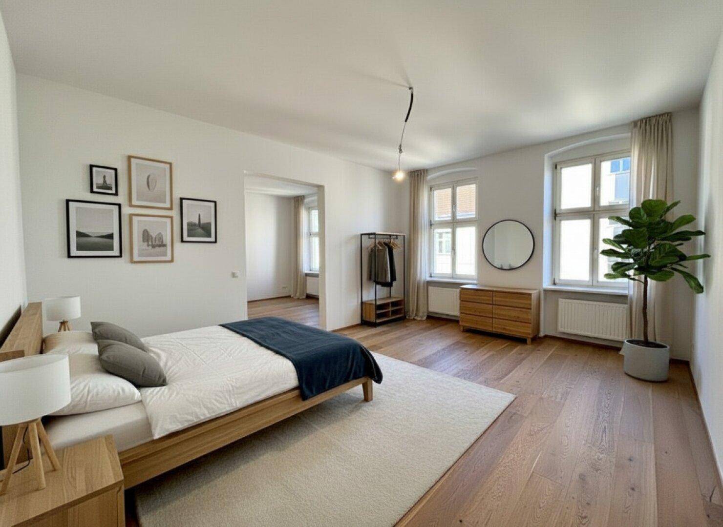 Geräumiges Schlafzimmer mit Holzbett, Parkettboden und großen Fenstern, die viel Licht hereinlassen.