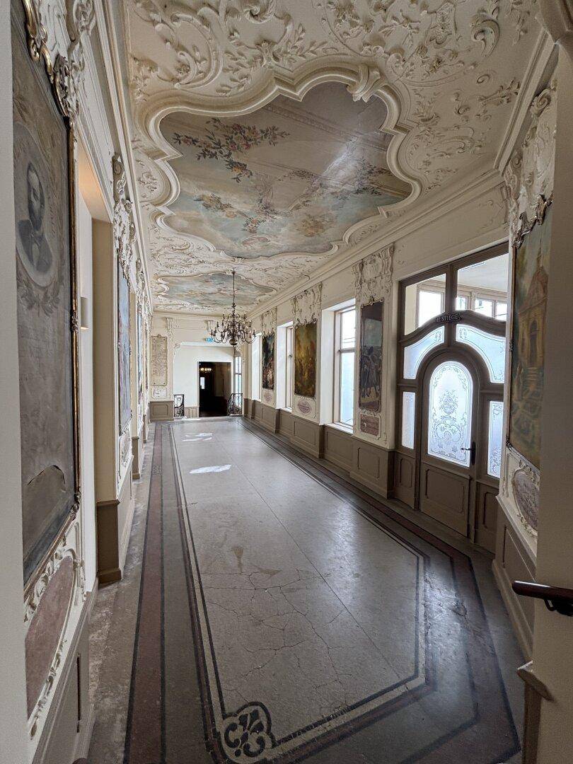 Prunkvoller Flur mit Stuckdecken, Wandmalereien und historischen Details.