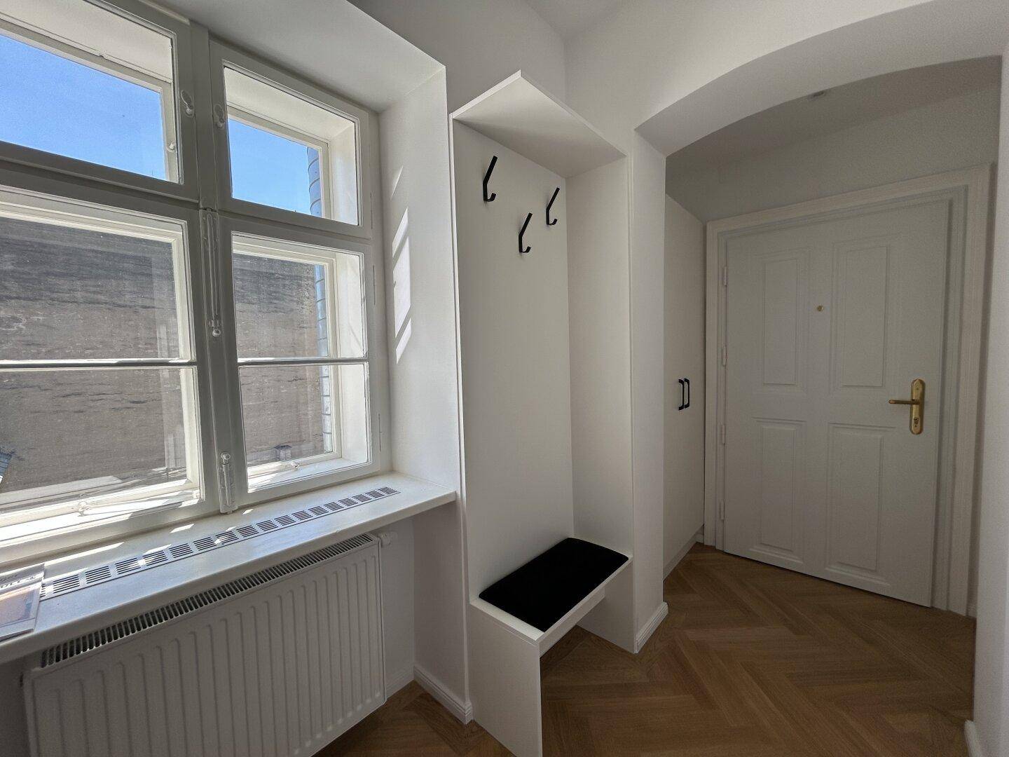 Eingangsbereich mit Fenster, integrierter Sitzbank und Garderobenhaken.