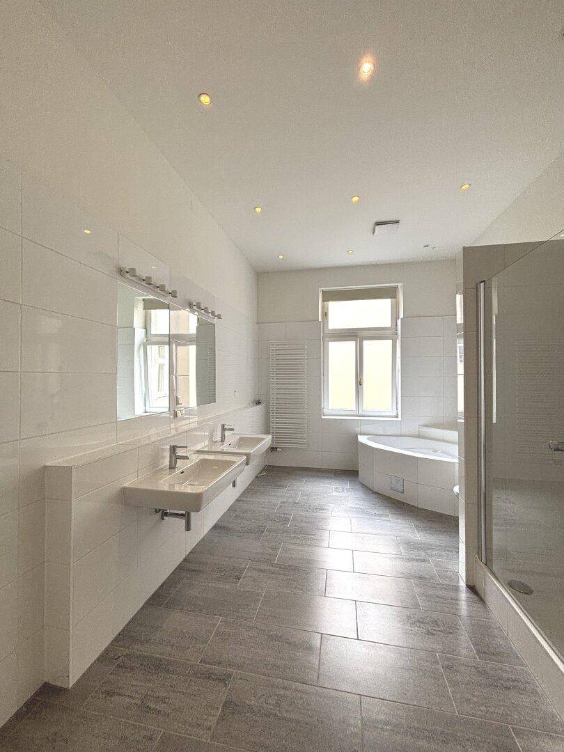 Modernes Badezimmer mit Doppelwaschbecken, Badewanne und separater Dusche.