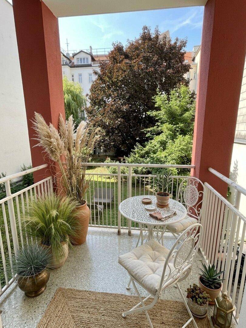 Gemütlicher Balkon mit Sitzgelegenheiten, Pflanzen und Blick ins Grüne.