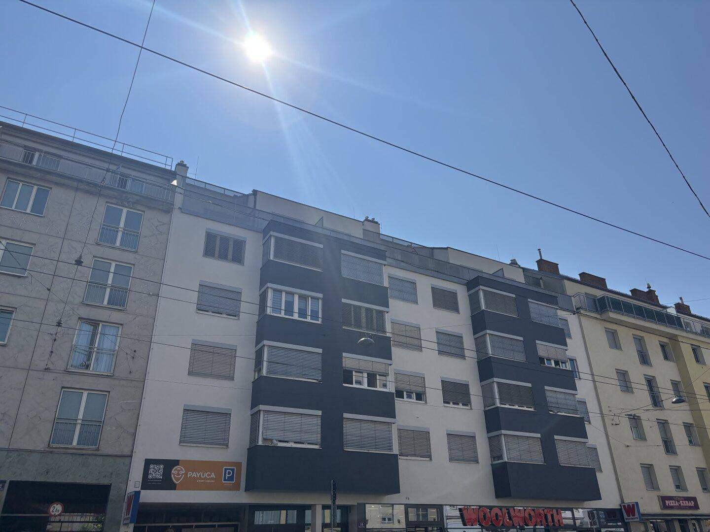 Ansicht der modernen Wohngebäude-Fassade unter blauem Himmel mit Sonnenschein.