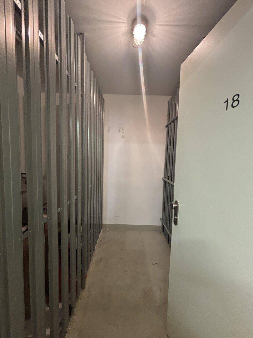 Praktischer Abstellraum im Keller mit Metallabtrennungen für zusätzliche Lagerfläche.