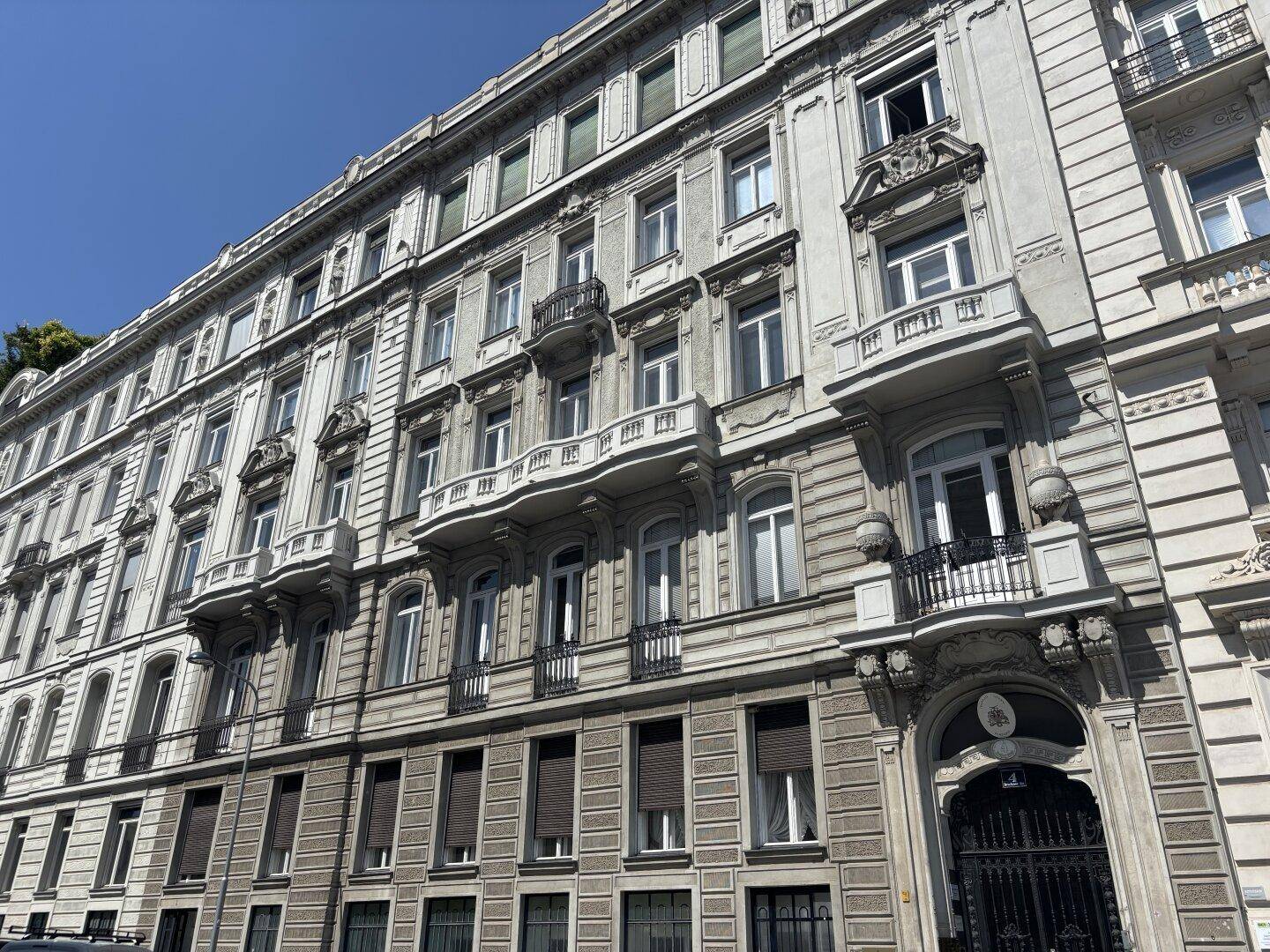 Historisches Mehrfamilienhaus mit klassischer Fassade, vielen Fenstern und Balkonen.