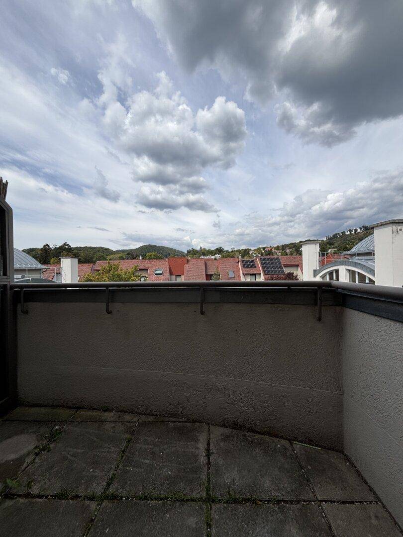 Dachterrasse mit weitem Blick über die Dächer der Stadt und die umliegende Hügellandschaft.