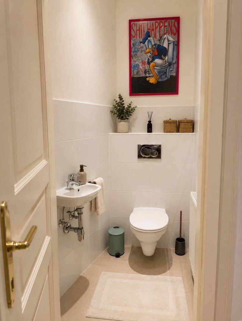 Modernes Gäste-WC mit wandhängender Toilette, kleinem Handwaschbecken und Fliesenboden.