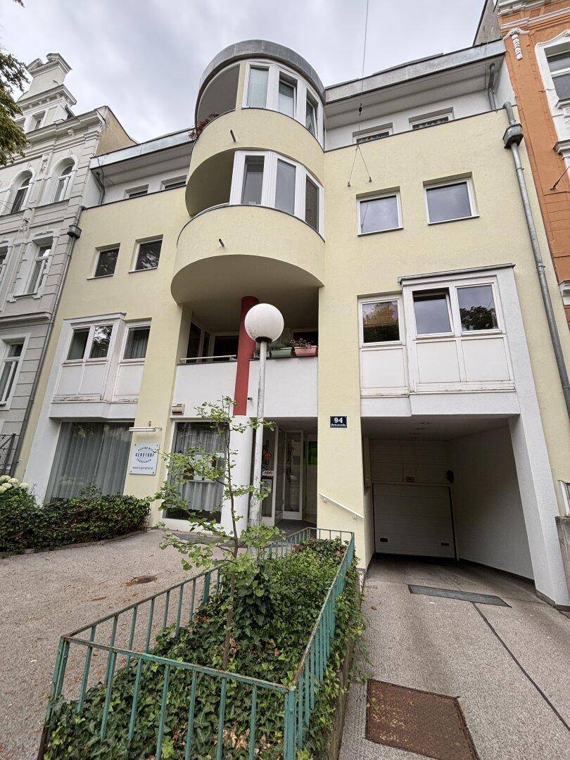 Ansicht der modernen Gebäudefassade mit Eingangsbereich und Tiefgaragenzufahrt.