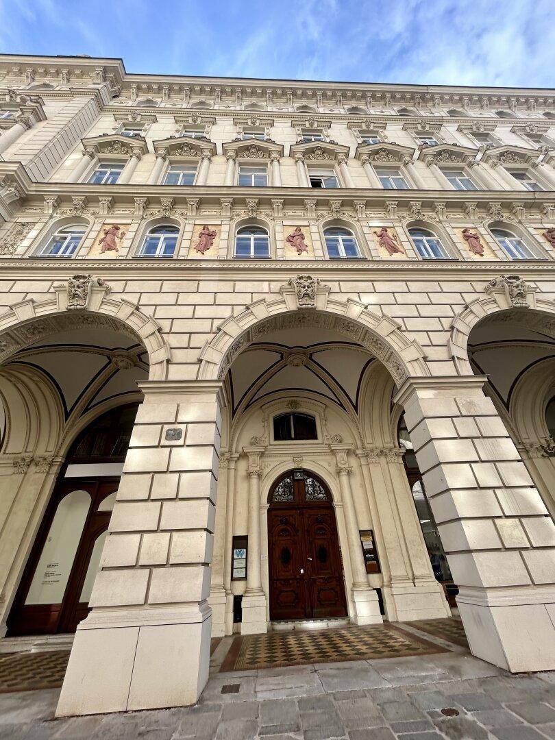 Prunkvolle Fassade eines historischen Gebäudes mit Bögen und Verzierungen.
