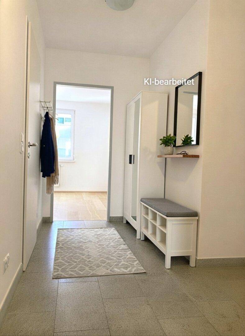 Heller Flur mit Fliesenboden, Garderobe und praktischer Sitzbank mit Stauraum.