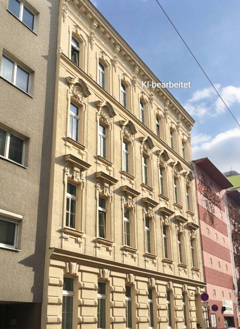 Historisches Gebäude mit eleganter, gut erhaltener Fassade und großen Fenstern, eingebettet in ein städtisches Umfeld.