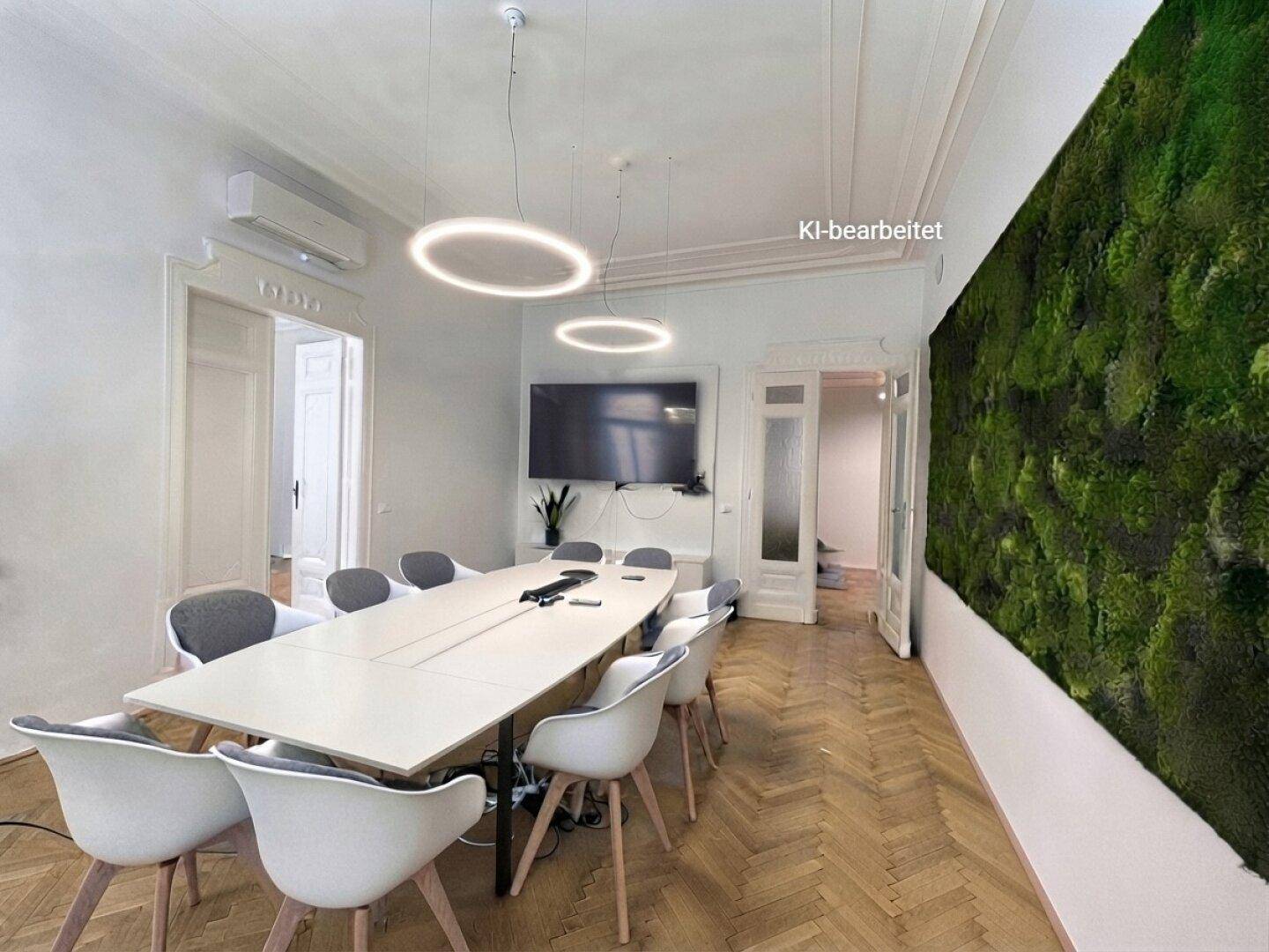 Heller Konferenzraum mit modernem Design, einem langen Tisch und einer auffälligen grünen Wanddekoration.