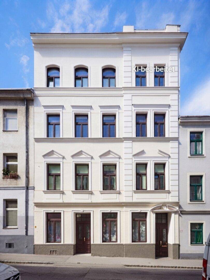 Klassische weiße Fassade eines Mehrfamilienhauses mit symmetrischen Fenstern und architektonischen Details.