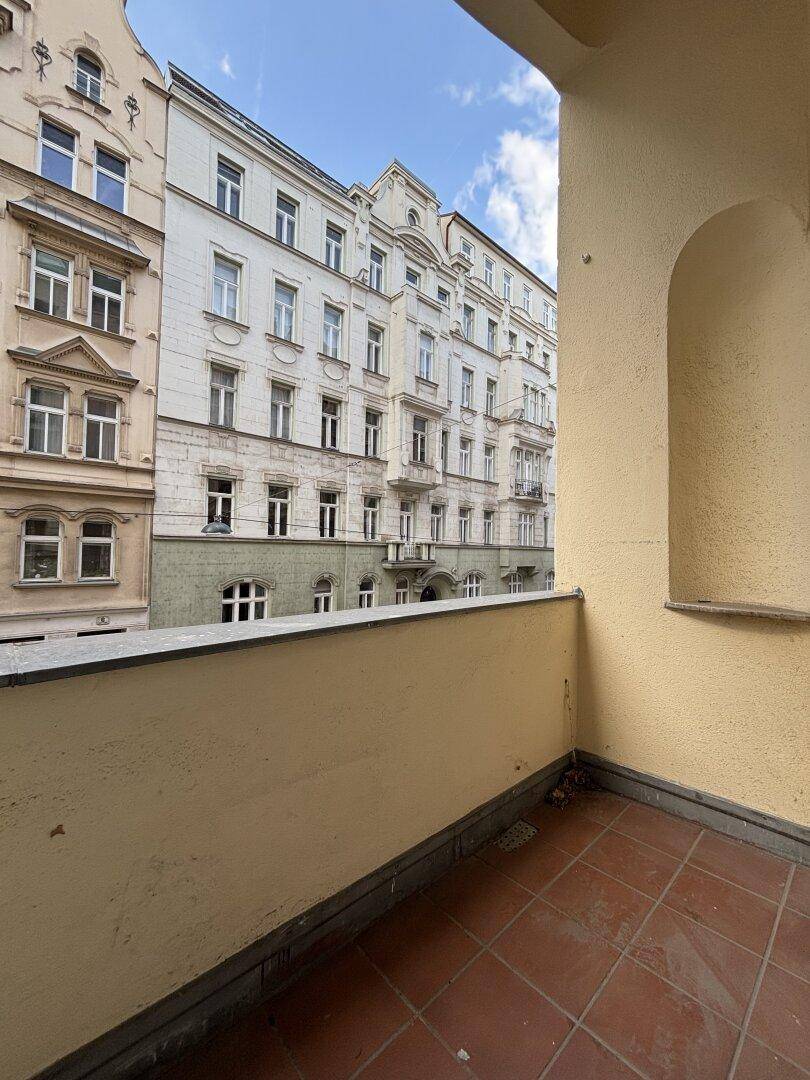 Balkon mit Terrakottafliesen und einem weiten Blick auf die historische Architektur der Nachbargebäude.