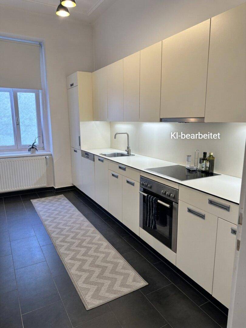 Moderne Einbauküche mit weißen Schränken, dunklem Fliesenboden und integrierten Geräten.