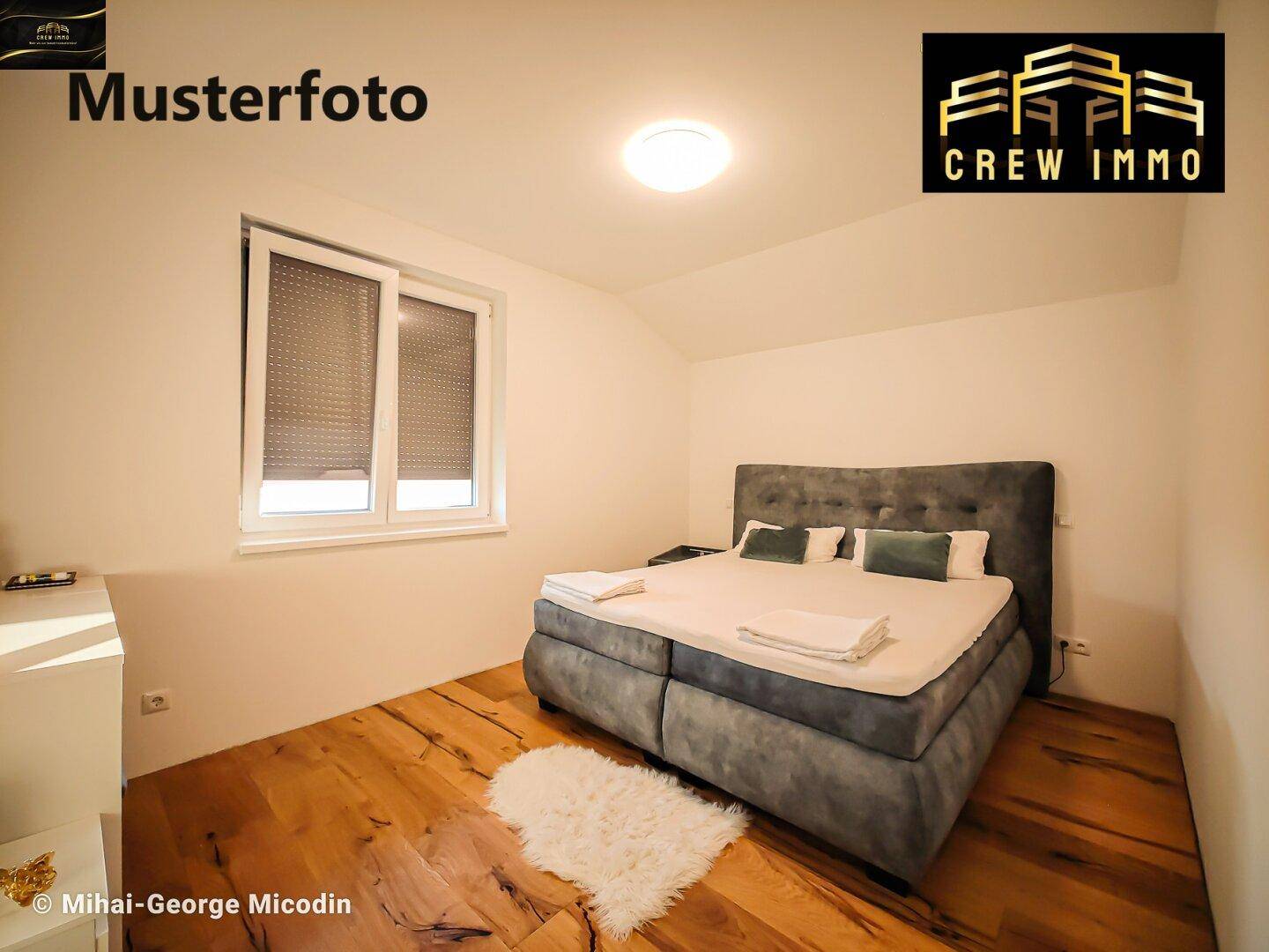 Gemütliches Schlafzimmer mit großem Bett, Holzdielenboden und Fenster mit Rollladen.