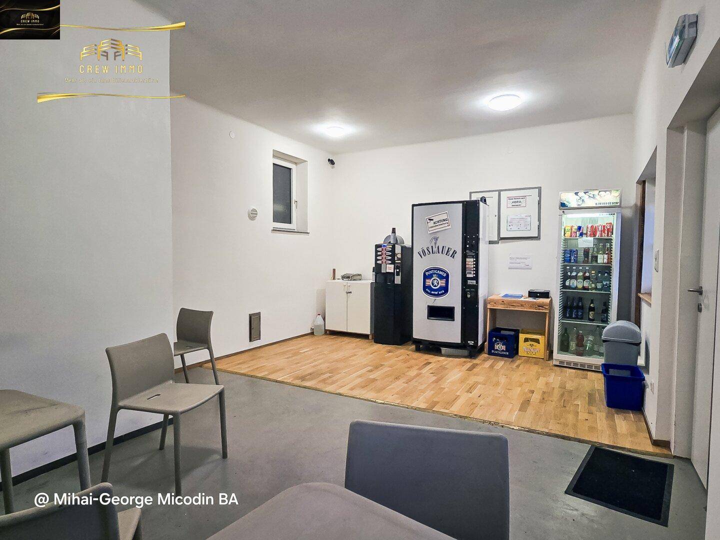 Innenraum mit Verkaufsautomaten, Getränkekühlschrank und Sitzgelegenheiten für Kunden.