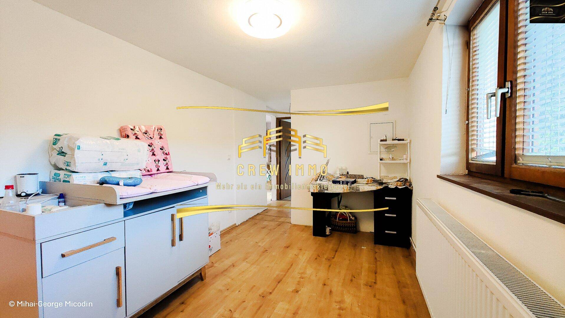 Kinderzimmer mit Wickeltisch, Schreibtisch und Fenster für ausreichend Tageslicht.