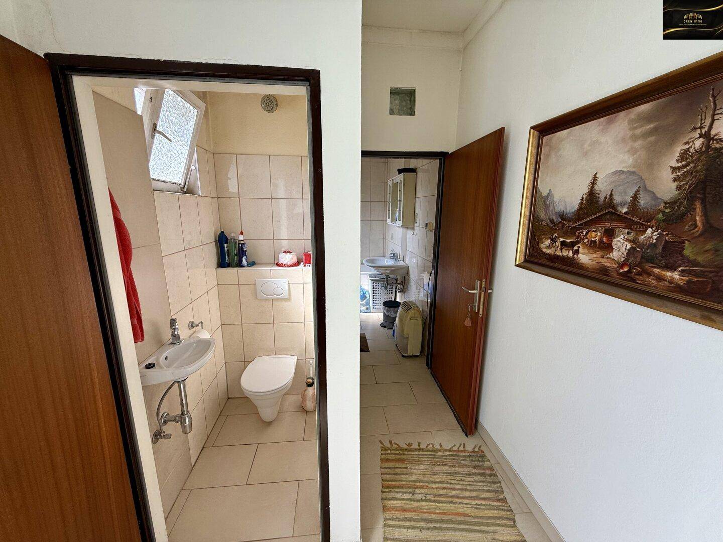 Flur mit Zugang zu einem separaten WC und einem Badezimmer, mit traditionellem Gemälde.