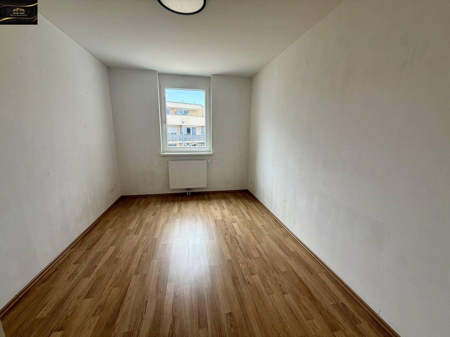 Helles Zimmer mit Laminatboden und Fenster, das sich gut als Kinder- oder Arbeitszimmer eignet.