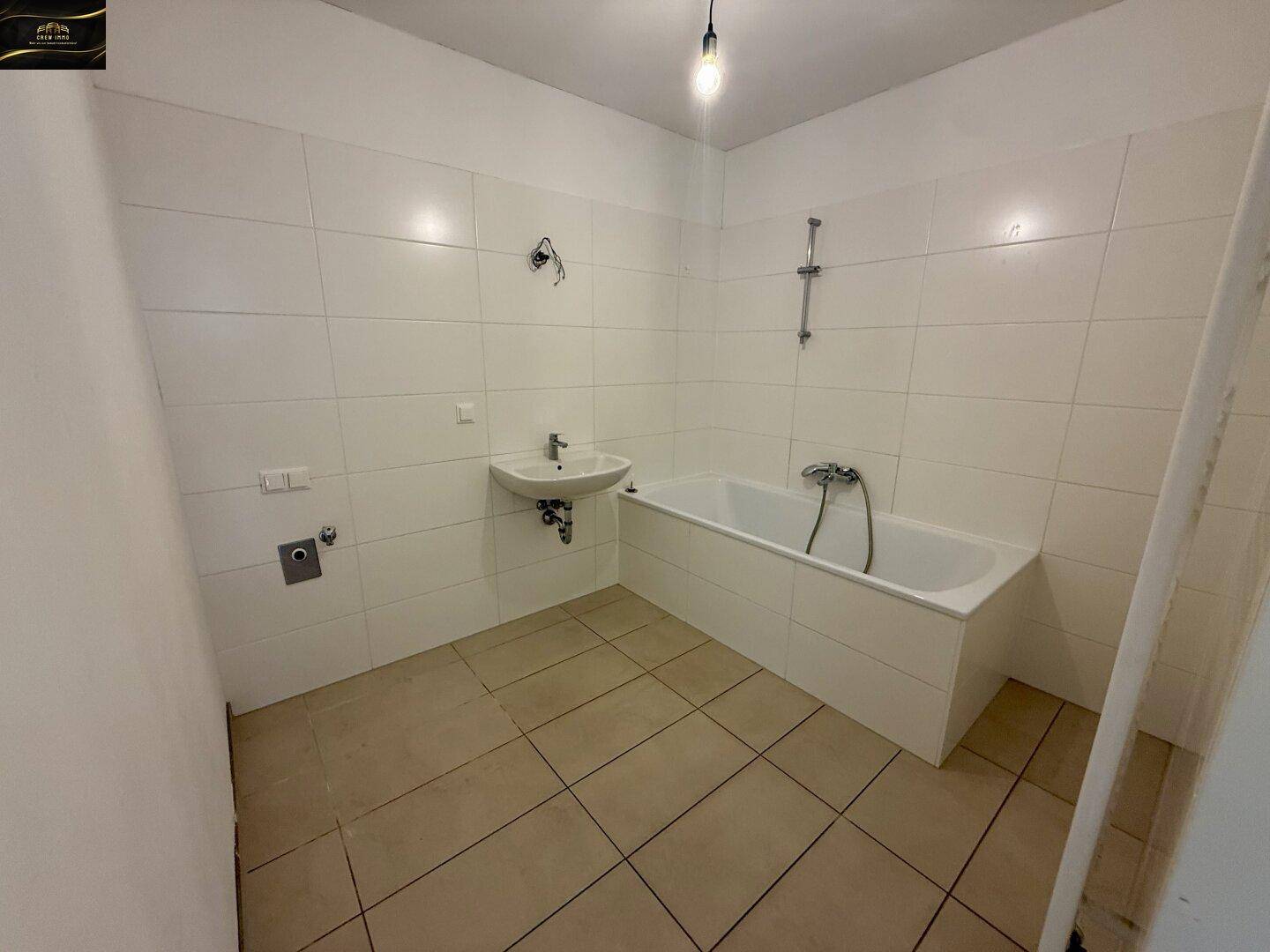 Modernes Badezimmer mit Badewanne, Waschbecken und weißen Wandfliesen.