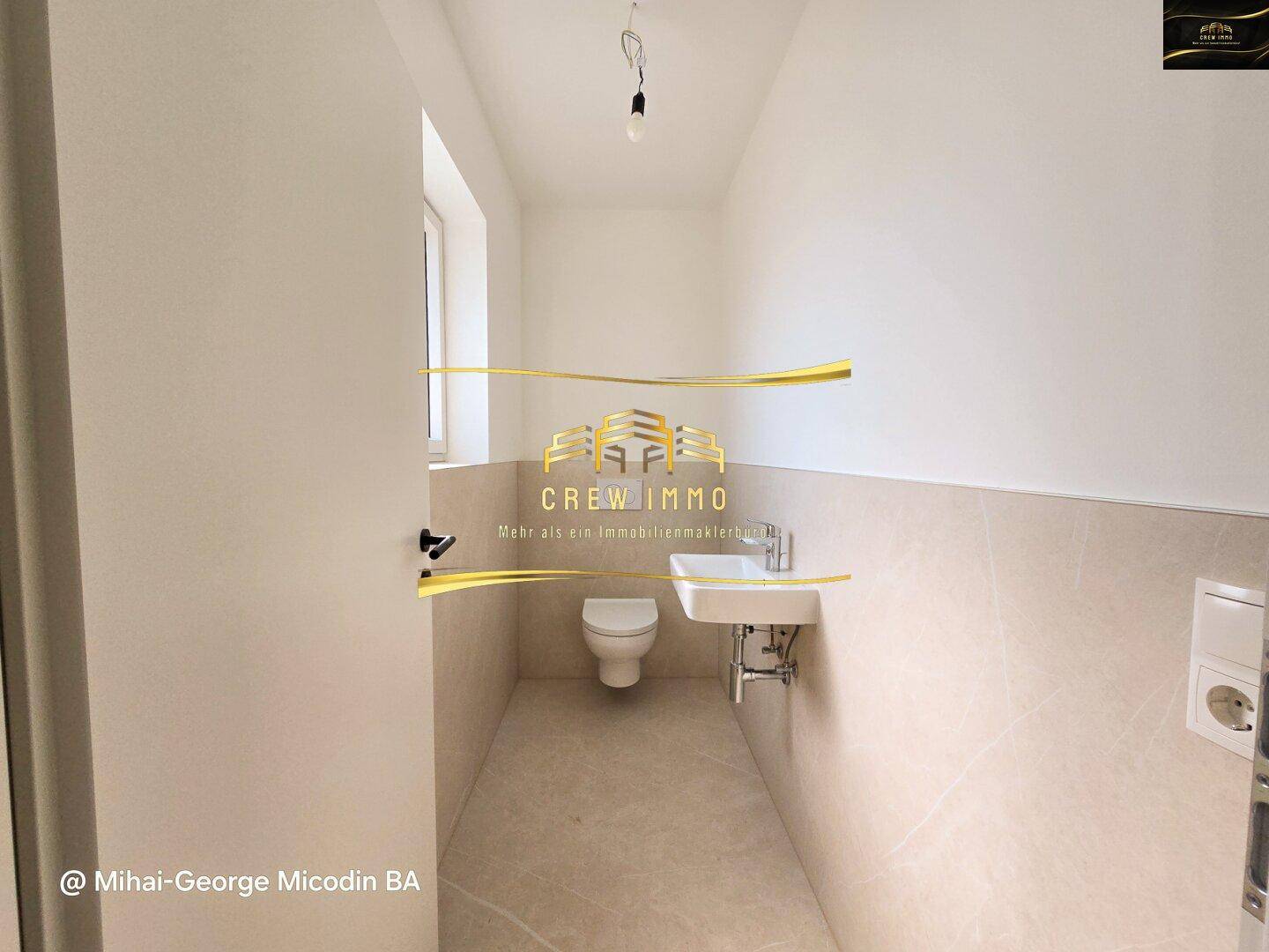 Modernes Gäste-WC mit Wand-WC und kleinem Waschbecken, hell gefliest.