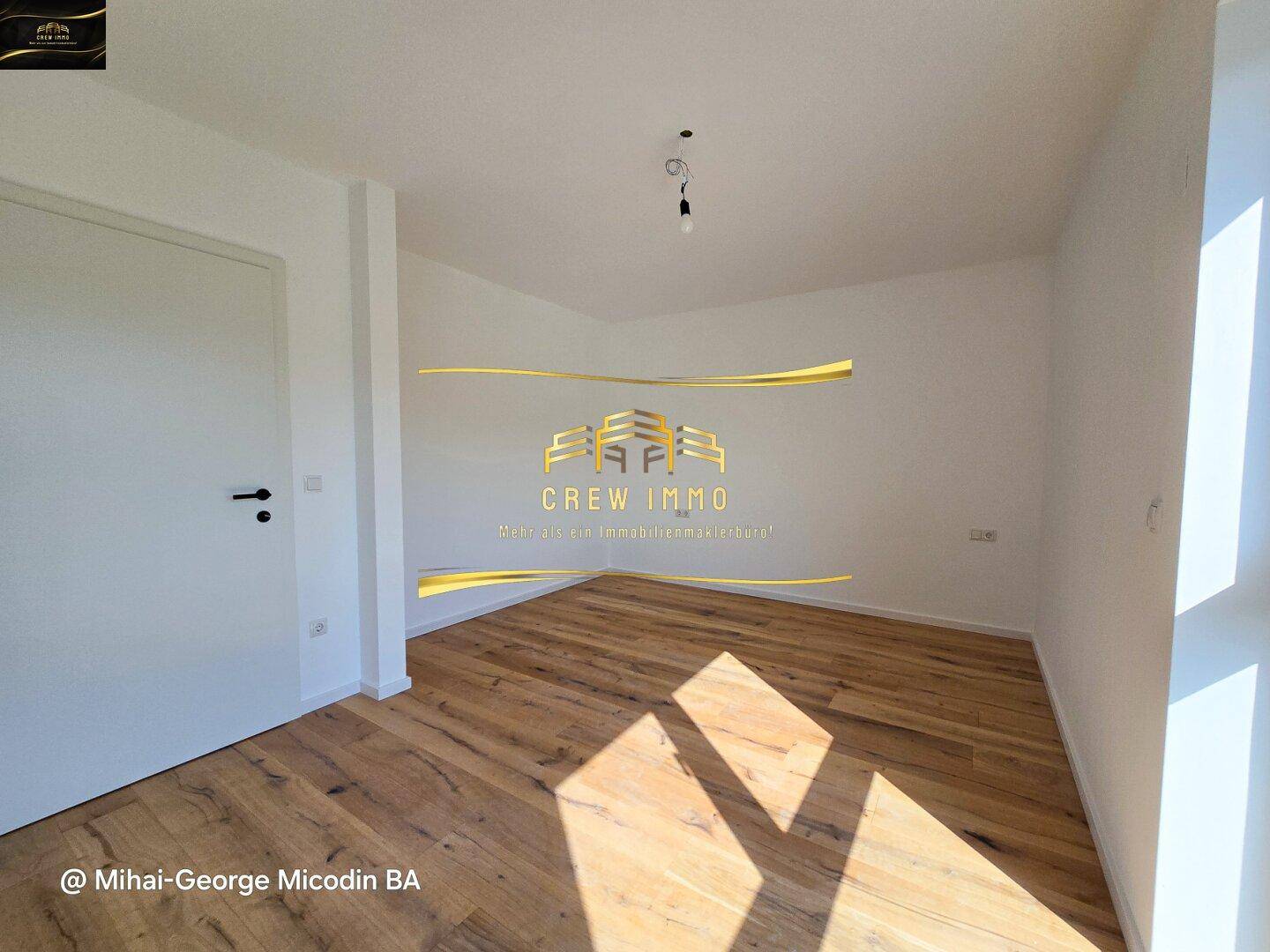 Sonniger Raum mit Holzboden und weiß gestrichenen Wänden, ideal als Kinder- oder Gästezimmer.