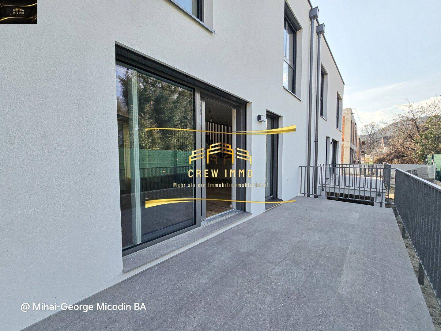 Geräumige Terrasse mit Fliesenboden und Zugang zum Garten, ideal für Outdoor-Aktivitäten.