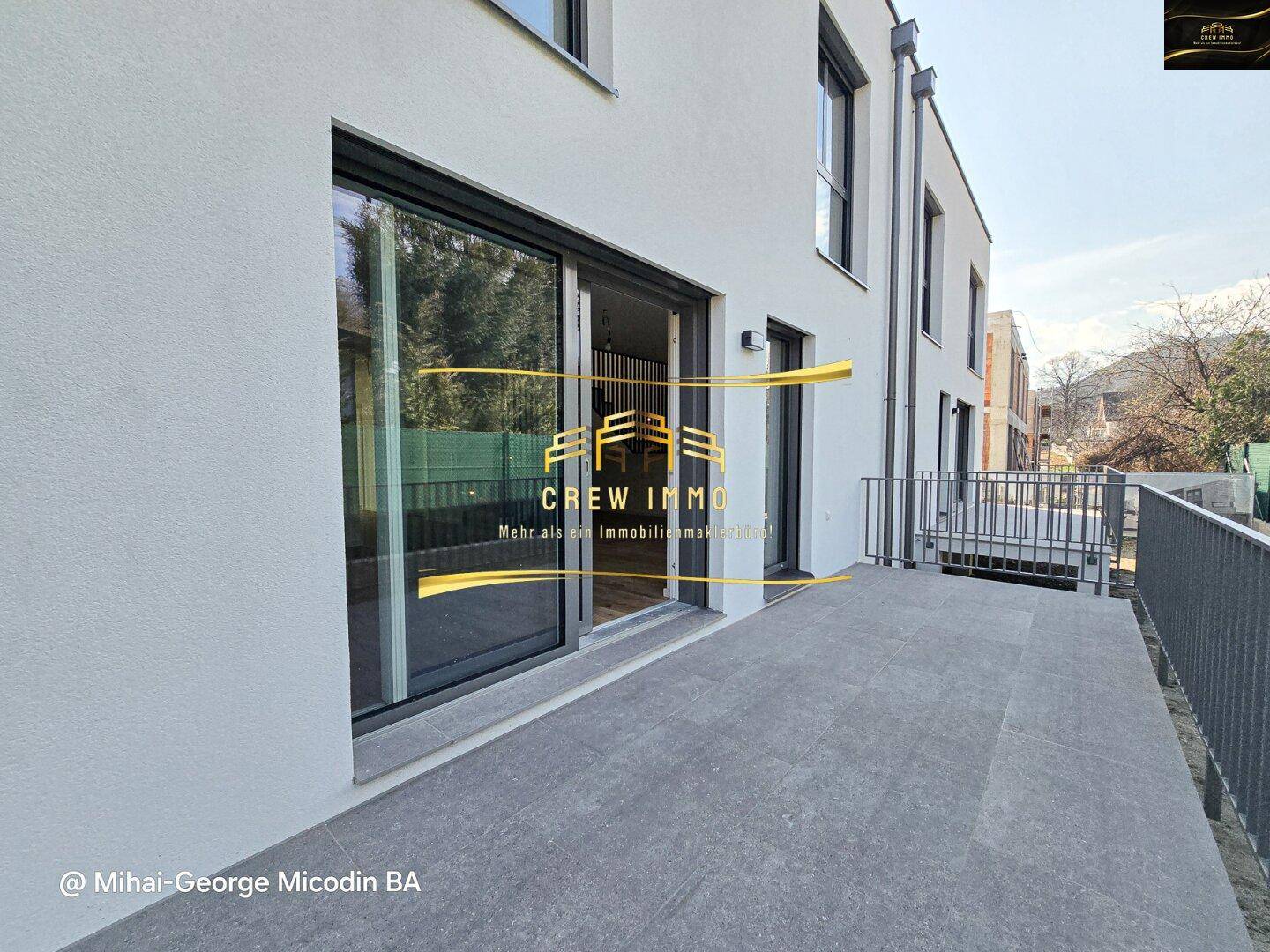 Geräumige Terrasse mit modernen grauen Fliesen, ideal für entspannte Stunden im Freien.