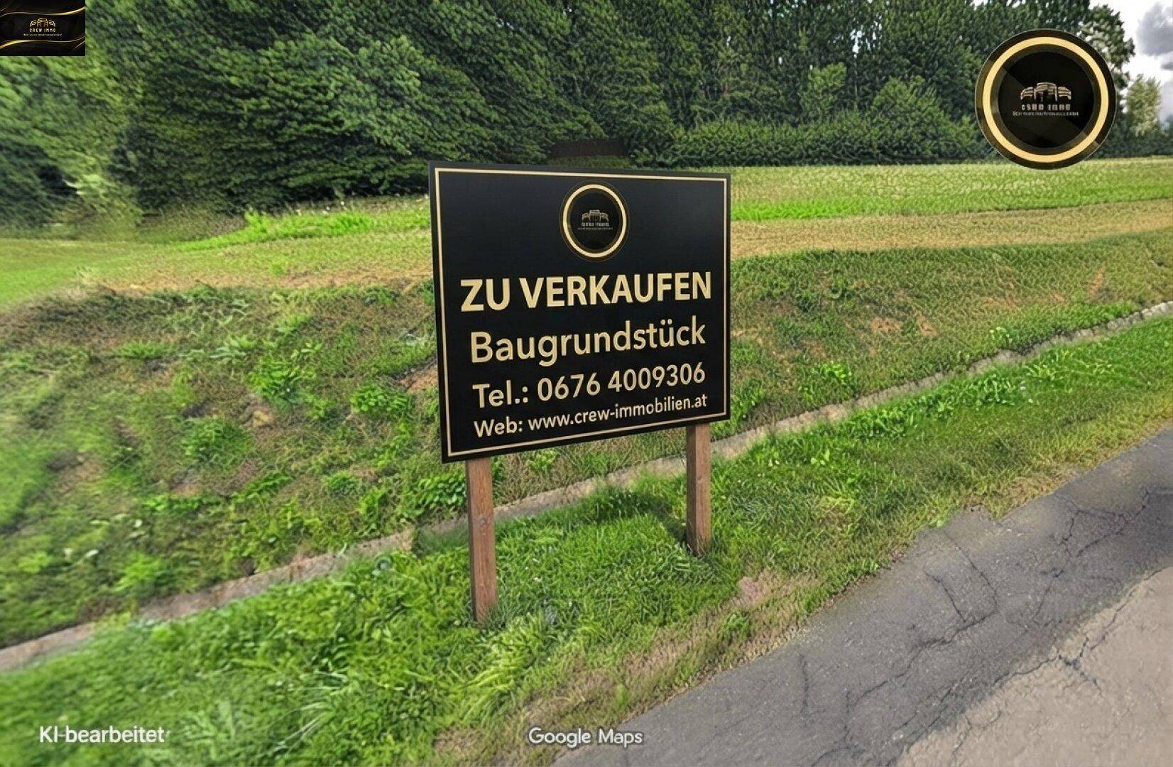 Nahaufnahme eines Verkaufsschildes für ein Baugrundstück, umgeben von grünen Wiesen und Bäumen.