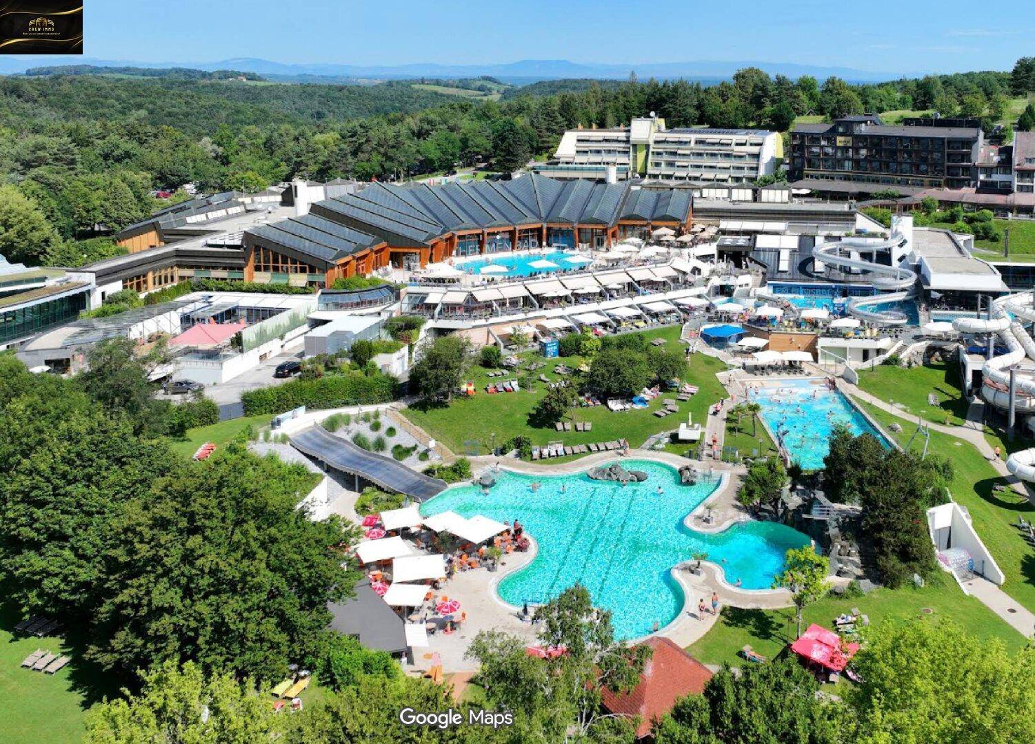 Luftaufnahme eines großen Resort-Komplexes mit mehreren Pools und weitläufigen Grünflächen.