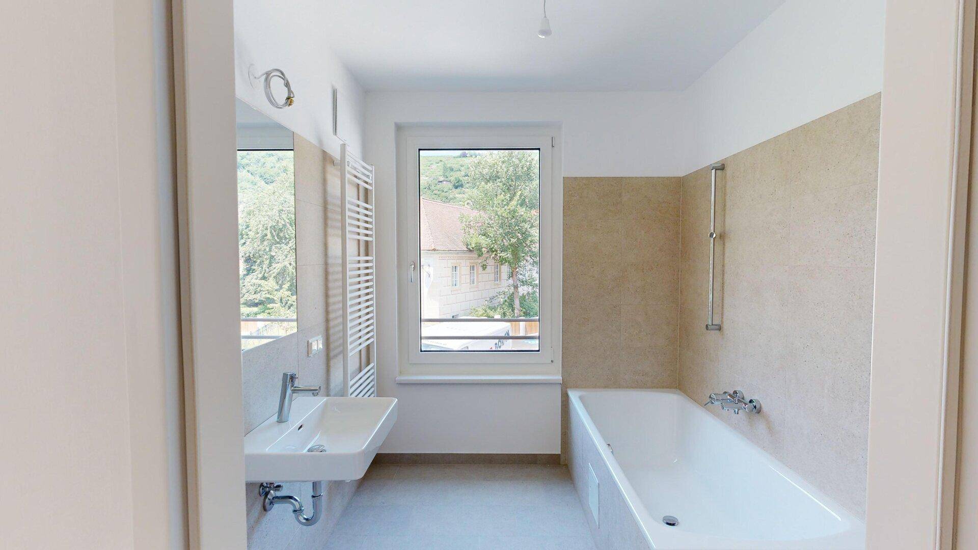 Modernes Badezimmer mit Badewanne, Waschbecken und beheiztem Handtuchhalter.