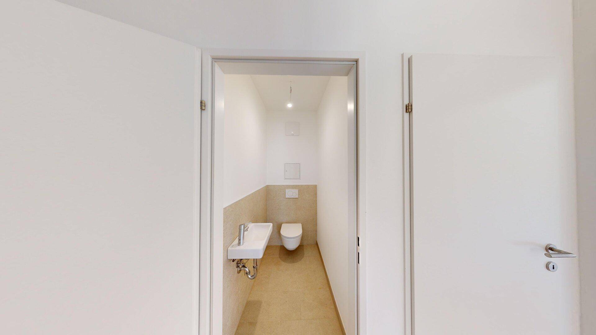 Kleines, modernes Gäste-WC mit wandhängendem WC und Handwaschbecken in neutralen Farben.