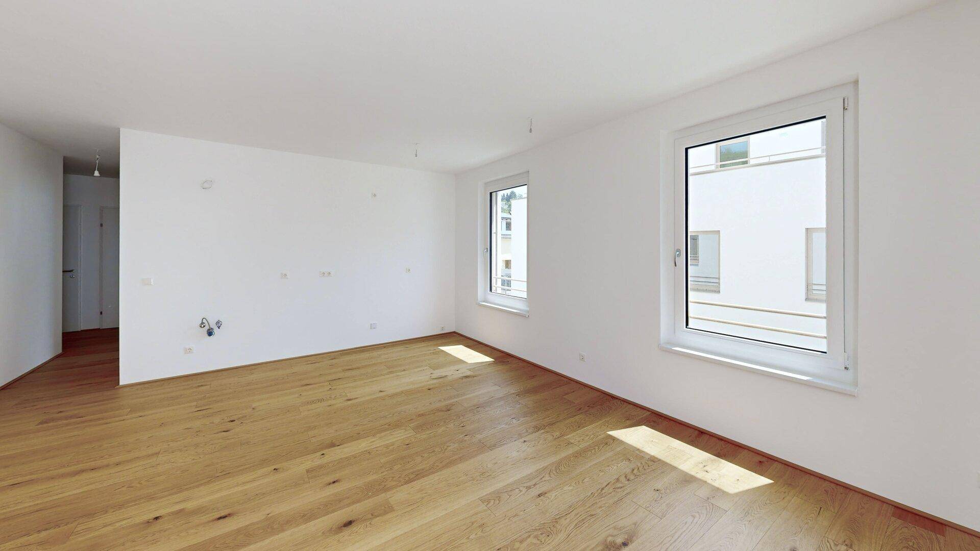 Geräumiges, helles Zimmer mit Eichenparkettboden und weißen Wänden, bereit zur individuellen Gestaltung.
