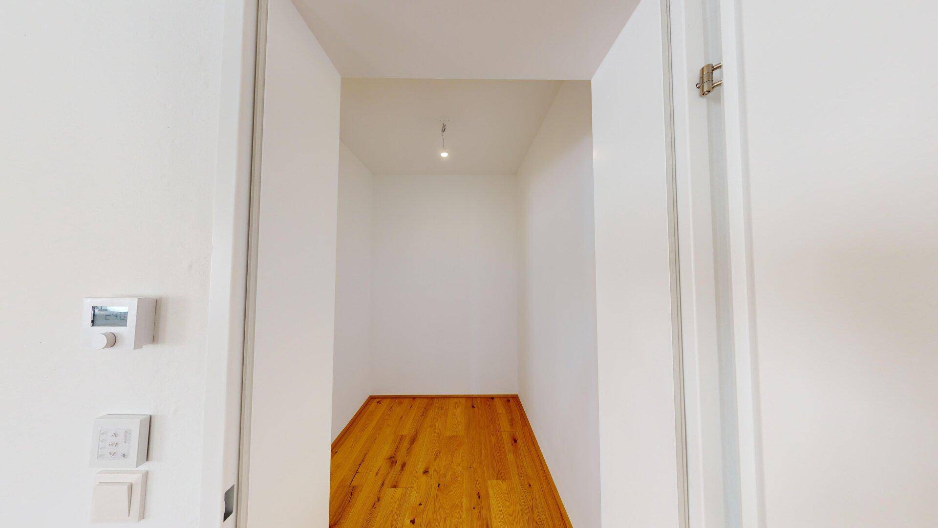 Heller Abstellraum mit Parkettboden, ideal für zusätzlichen Stauraum oder als begehbarer Kleiderschrank.