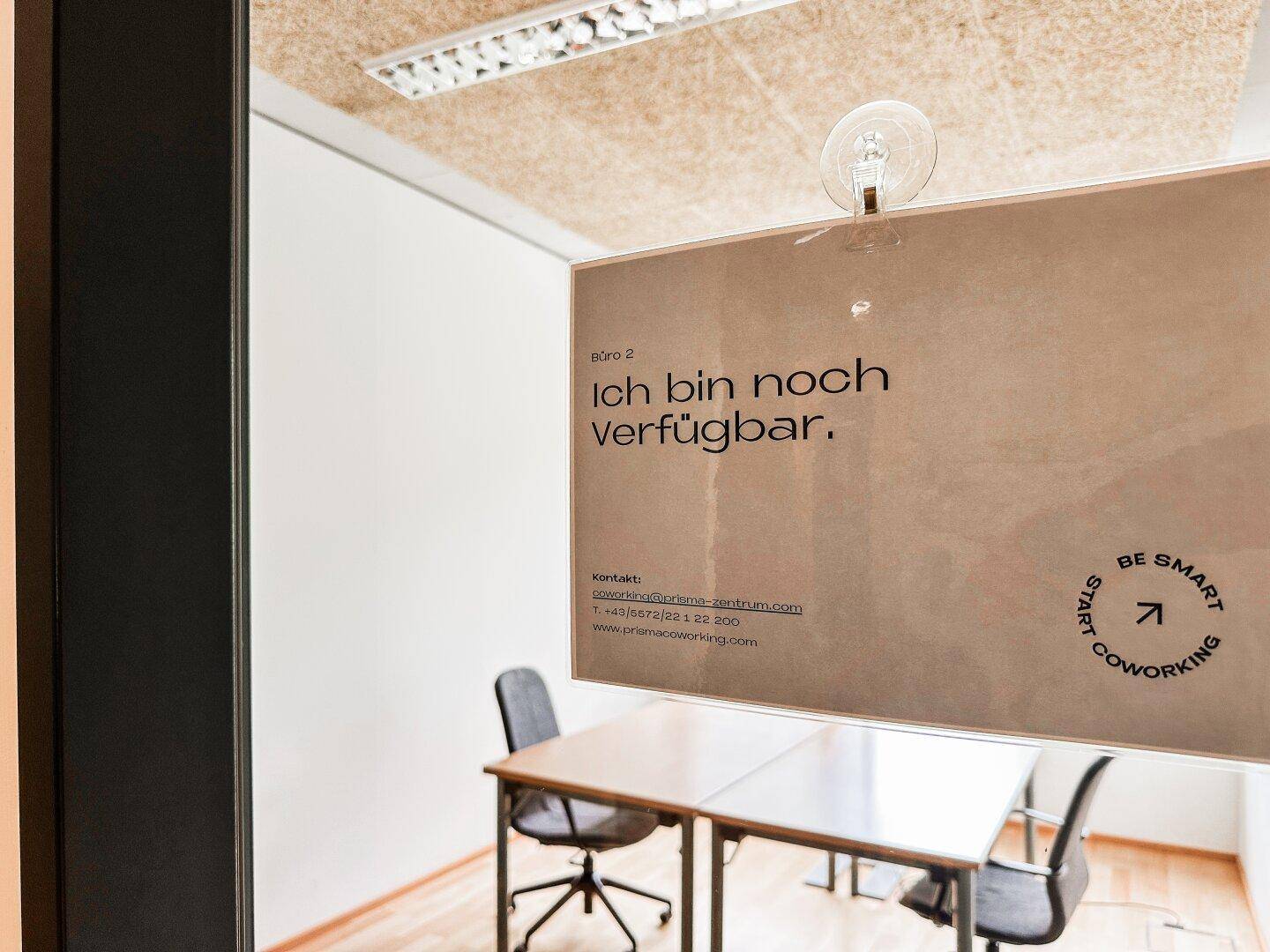 Nahaufnahme eines Schildes an einer Glastür, das die Verfügbarkeit des Büros anzeigt.