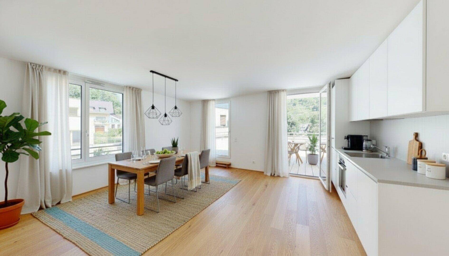 Offener Wohn-Essbereich mit moderner Einbauküche, Holzboden und Zugang zum Balkon.