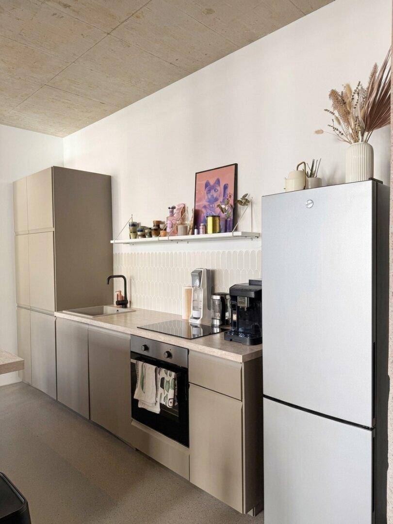 Küchenzeile mit integriertem Backofen, Induktionskochfeld und einem großen Kühlschrank.