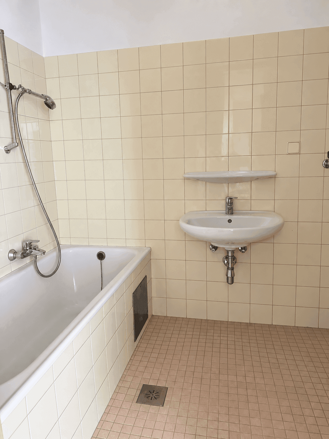 Helles Badezimmer mit Badewanne und Waschbecken in klassischem Design.