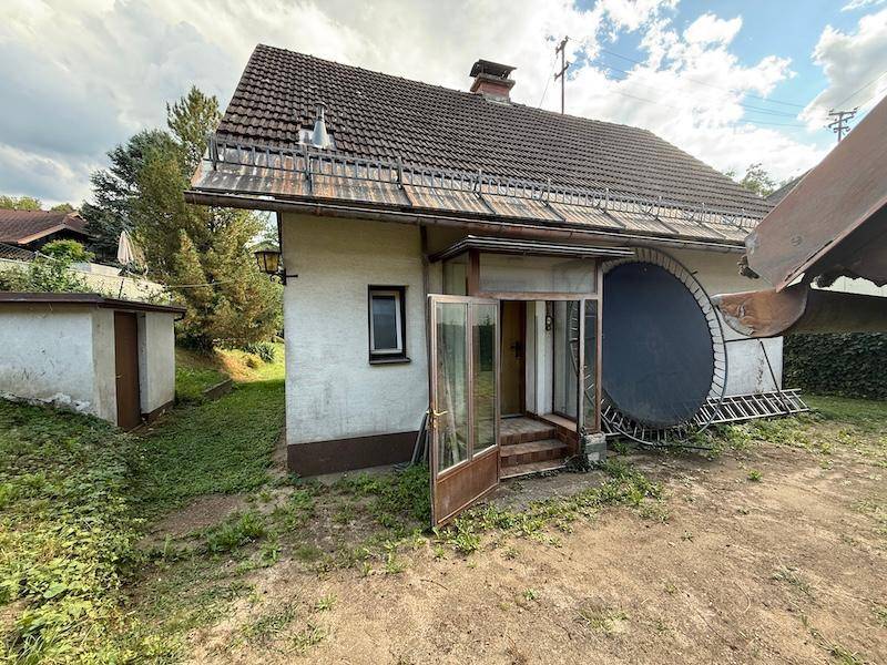 Eingangsbereich eines Hauses mit Vordach, daneben ein Trampolin und ein kleiner Schuppen.