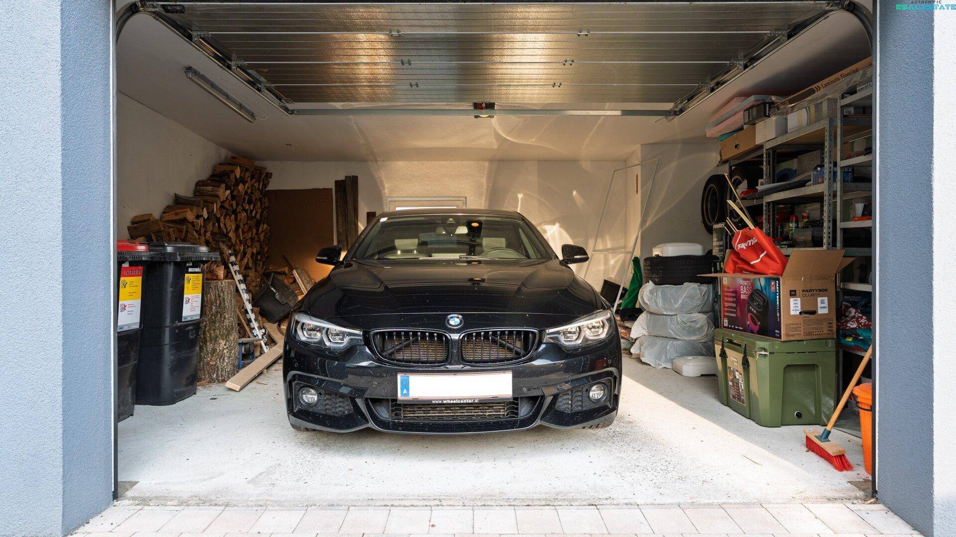 Geräumige Garage mit einem Auto, Holzstapel und Lagerregalen.