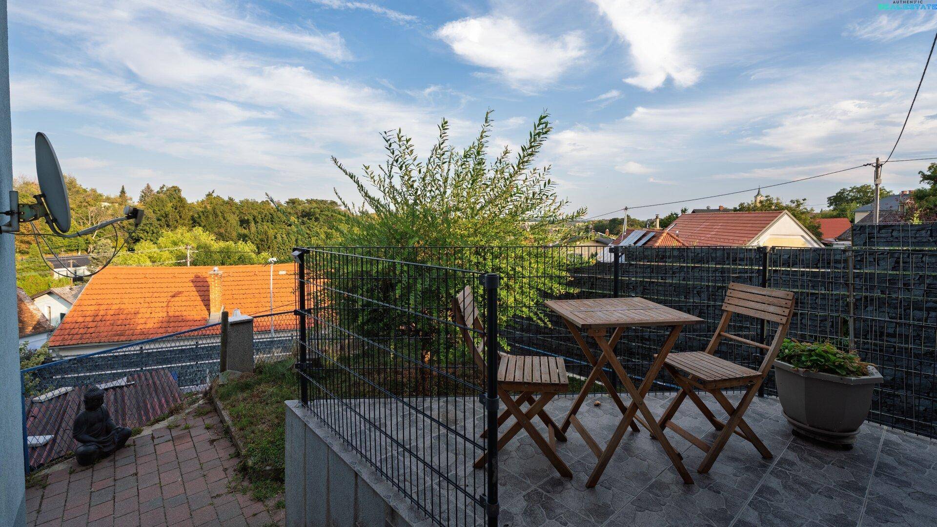 Kleiner Balkon mit Holztisch und Stühlen, bietet Blick auf die Umgebung.