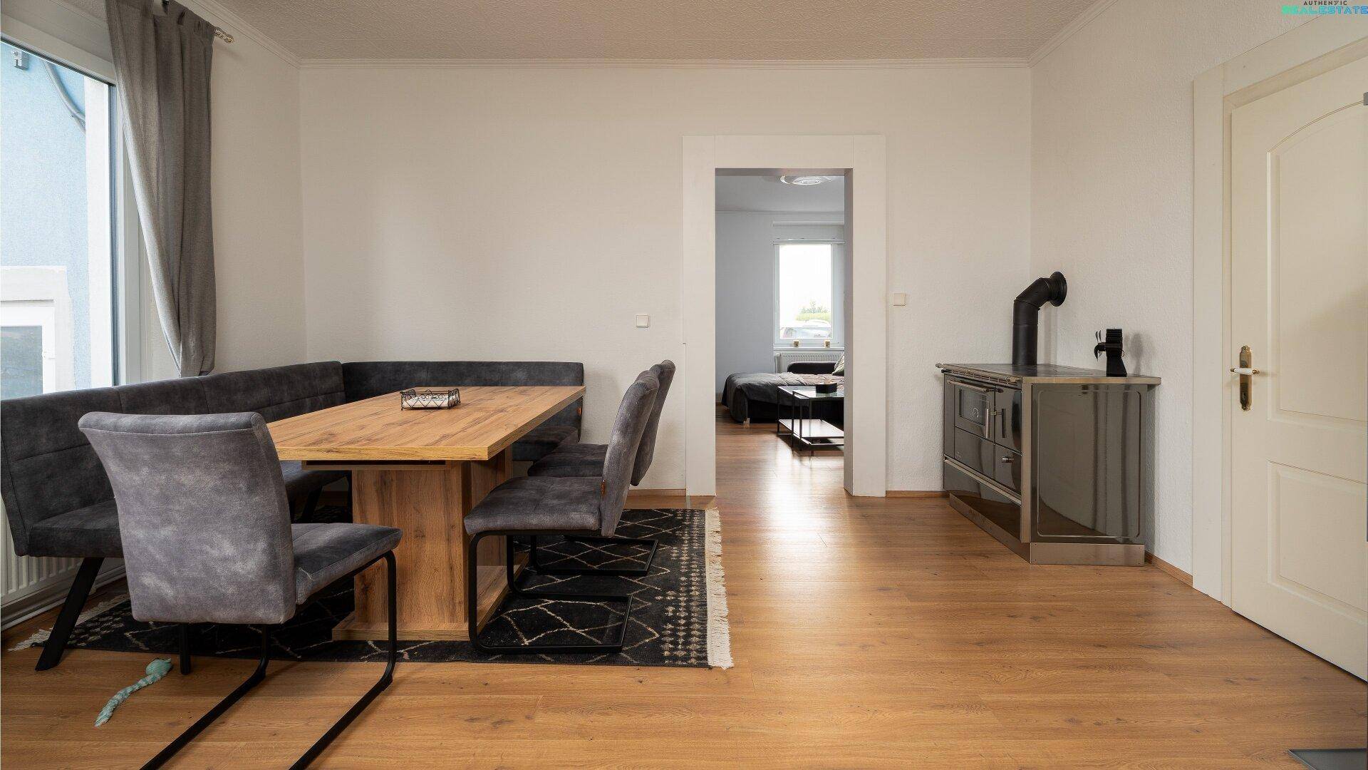 Gemütlicher Essbereich mit Holzofen und Zugang zu einem weiteren Zimmer.