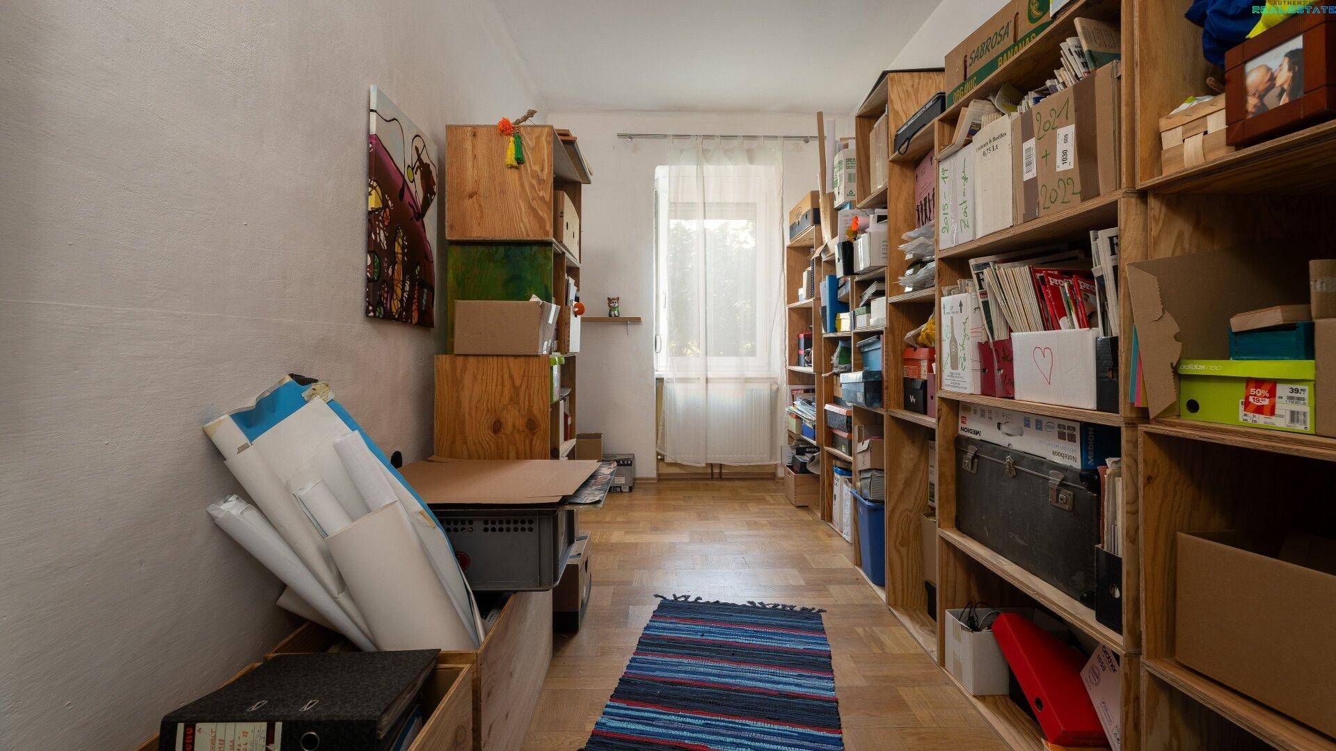 Abstellraum oder Werkstatt mit vielen Regalen, Kisten und einem Fenster.