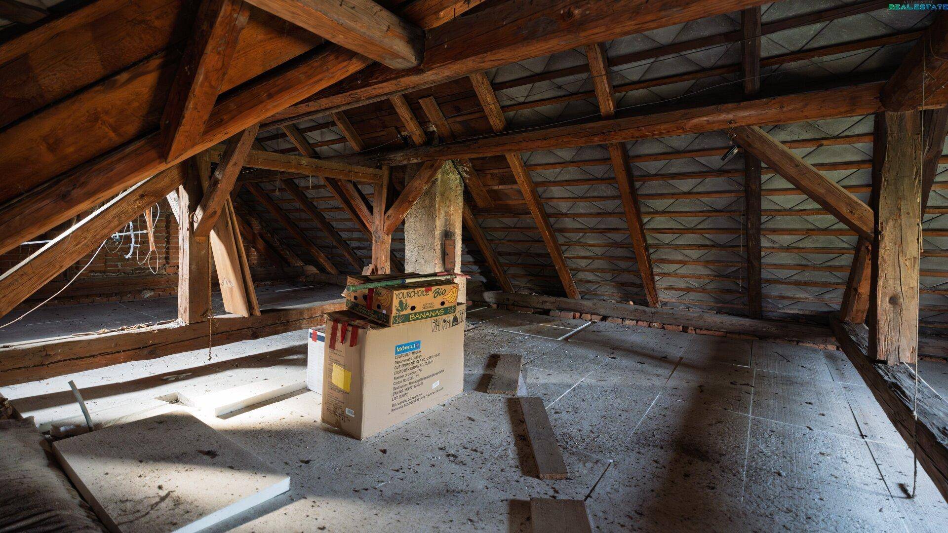 Unausgebauter Dachboden mit sichtbaren Holzbalken und Lagerfläche.