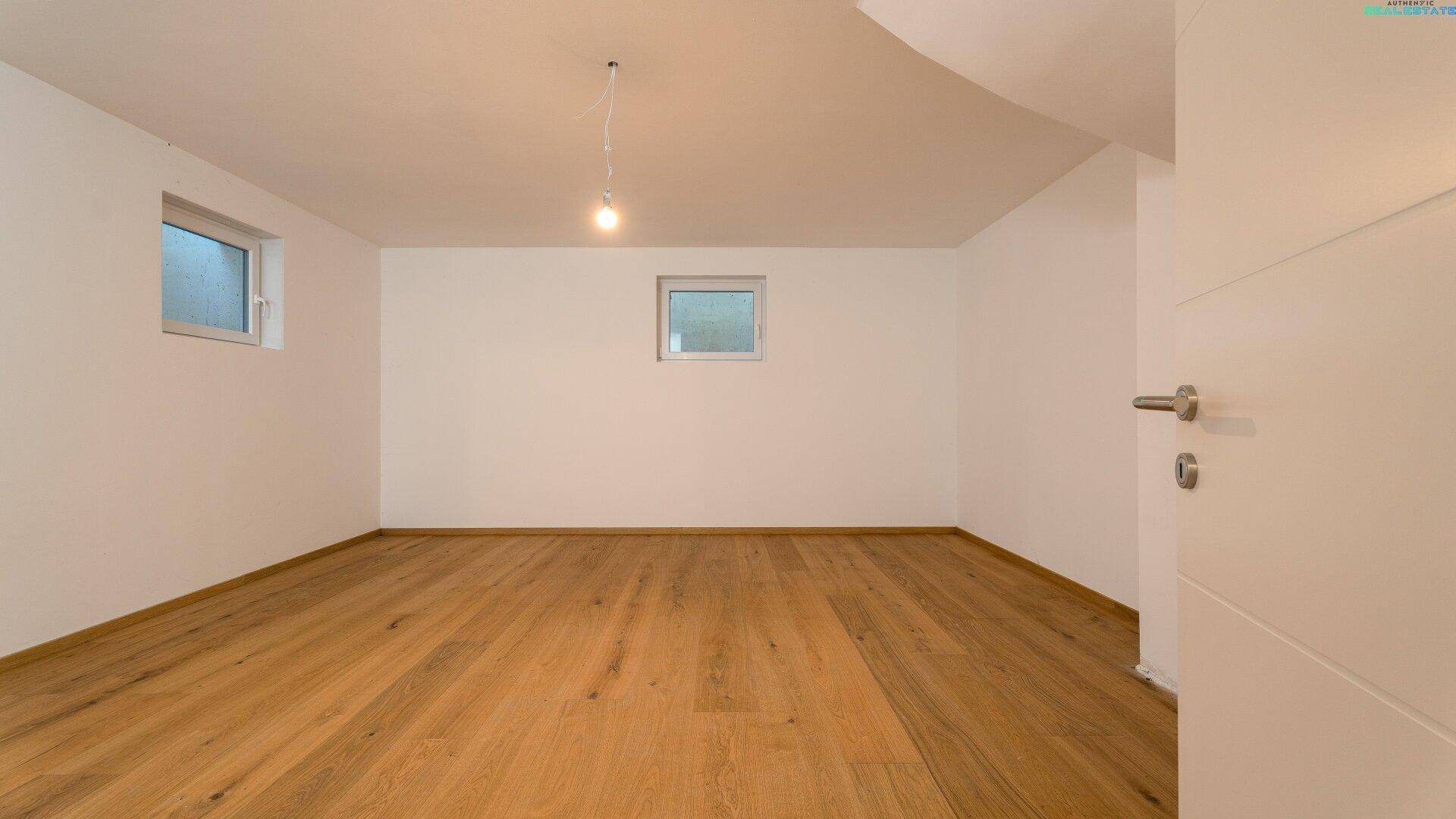 Helles Zimmer mit Holzboden und zwei Fenstern, ideal als Schlaf- oder Arbeitszimmer.