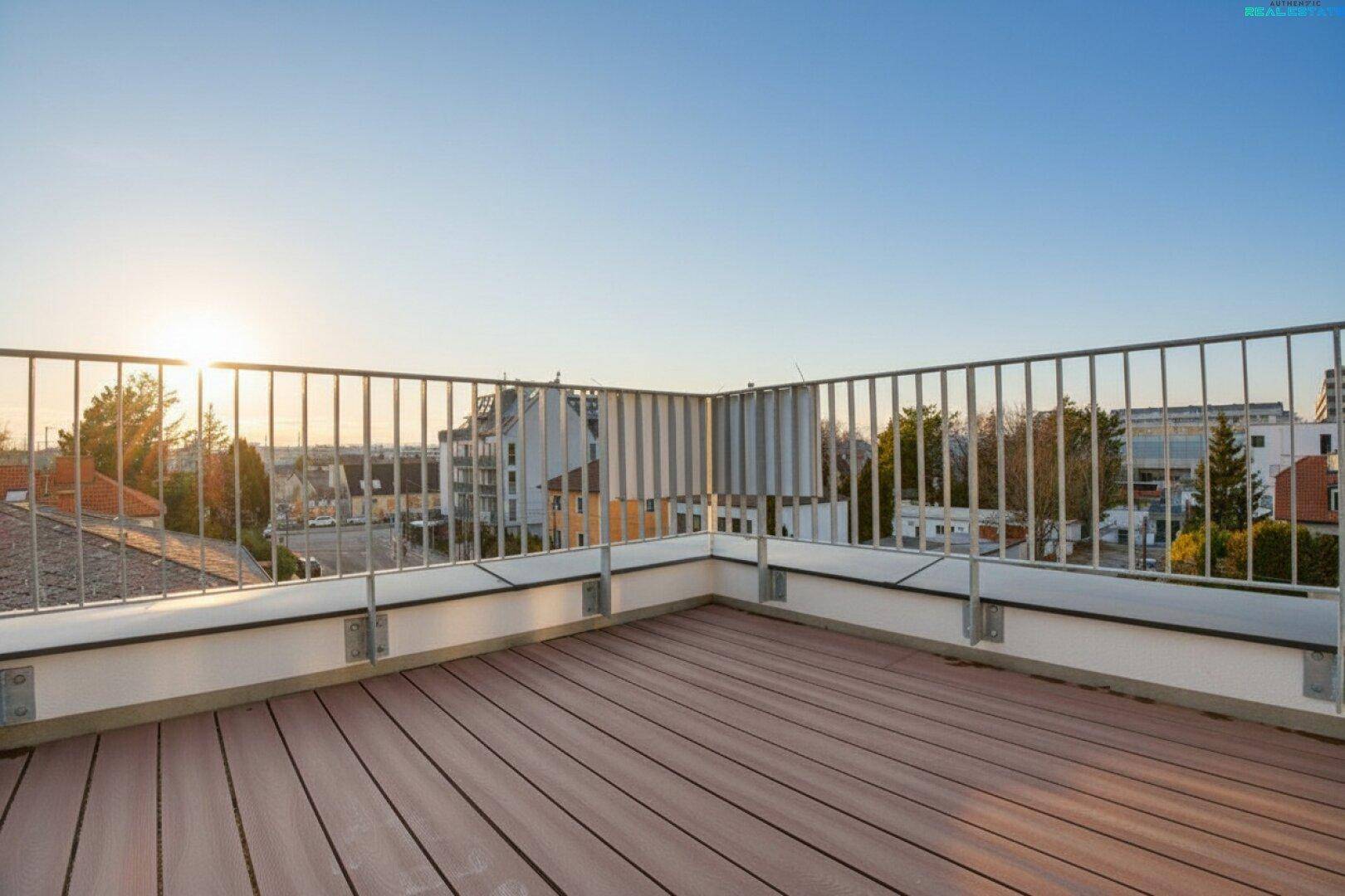 Geräumige Dachterrasse mit Holzboden und Metallgeländer, bietet einen weiten Blick über die Umgebung.