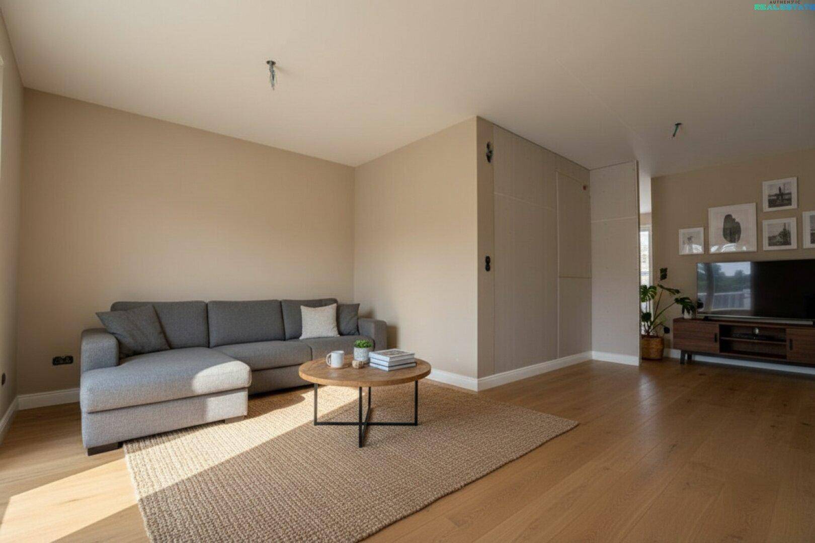 Gemütliches Wohnzimmer mit Holzboden, beiger Wandfarbe, Sofa und Teppich, ideal zum Entspannen.